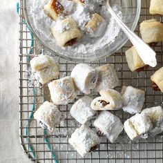 there are several desserts on the cooling rack and one is filled with powdered sugar