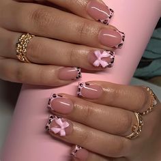 a woman's hands with pink and black nail polishes on her nails, holding a coffee cup