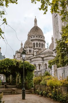 an old building with many spires in the middle of trees and bushes around it