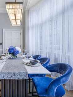 a dining room table with blue chairs around it