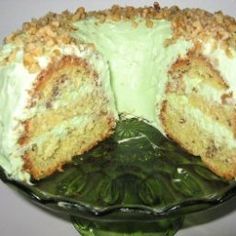 a cake that has been cut in half on a green platter with one slice taken out