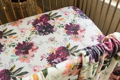 a baby crib with a floral blanket on it