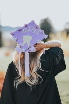 a woman wearing a purple graduation cap with poodles on it's head