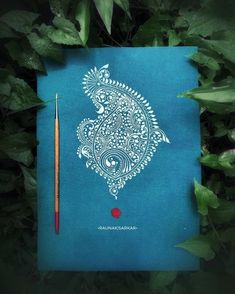 a blue notebook with an intricate design on the cover and a pencil in front of it