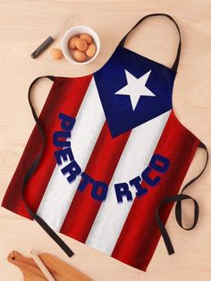 an apron with the word puerto on it next to utensils, eggs and spoons