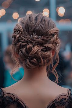 the back of a woman's head with hair in a braid and pearls on it