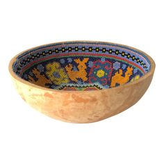 a wooden bowl with beaded designs on it