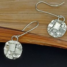 Are these lovely squares trapped in a circle ?  Or is this circle invaded by these squares ? Well, it is a beautiful dangle sterling silver earring. Handmade textured and swiftly moving it gives you the little sparkle your outfit may need. This earrings has a matching items : Ring in the rings section: https://www.etsy.com/your/shops/SilveryTide/tools/listings/stats:true/1259629317 Necklace in the necklace section: https://www.etsy.com/your/shops/SilveryTide/tools/listings/stats:true/1245630774 Disk Earrings, Earring Handmade, Earrings Geometric, Disc Earrings, Silver Earring, Geometric Earrings, Earrings Dangle, Aesthetically Pleasing, Matching Items