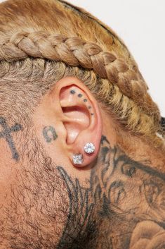 a man with tattoos and piercings on his ear