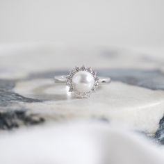 This ain't no classic pearl. It's got a halo for extra angelic points. It's elegant, sophisticated, and fantastic. Center Stone: Pearl Center Stone Weight: 8mm Overall Dimension: 9mm(L) x 9mm(W) Carat Weight: 0.49 ctw Elegant Pearl Promise Ring With Halo Setting, Elegant Pearl Ring With Halo For Wedding, Formal Round Cut Halo Pearl Ring, Classic Pearl Ring With Halo Setting, Classic Round Pearl Ring With Halo Setting, Elegant Pearl Ring With Halo Setting, Classic Halo Pearl Ring, Elegant Round Cut Pearl Ring With Halo Setting, Elegant Pearl Ring With Halo Design For Wedding