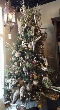 a christmas tree decorated with deer antlers and pine cones