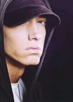 a young man wearing a hoodie and looking at the camera with a serious look on his face