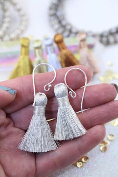 Who's the sparkliest girl at the party? You will be with these NEW metallic tassels! Making your own tassel earrings is easy peasy with these sparkly cuties. Simply slide an ear wire onto the ready-made loop at the top of these, and sparkle-city, here you come! Length: 1.25" Material: Polyester Individually wrapped. Twisted loop at top to string through and attach to your creations. See photos for close-up. ⚡ ⚡⚡ ⚡ ⚡⚡ ⚡ ⚡ Want to turn these cotton cuties into earrings?! It's super simple! You jus Making Earrings, Shopping World, Bright Gold, How To Make Earrings, Easy Peasy, Super Simple, Ear Wire, Tassel Earrings, White Silver