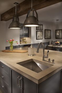 a kitchen with an island sink and hanging lights