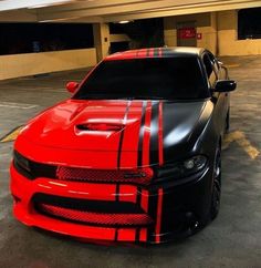 a red and black car parked in a parking lot