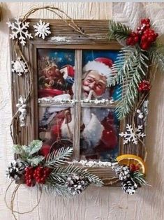 an old window decorated with christmas decorations and pine cones, is hung on the wall