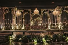 an elaborately decorated stage with chandeliers and greenery