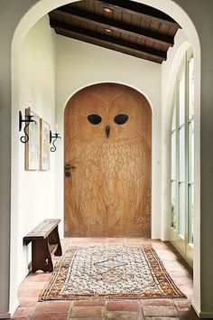 an owl carved into the side of a door in a hallway with arched doorways