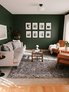 a living room with green walls and pictures on the wall above the couches,