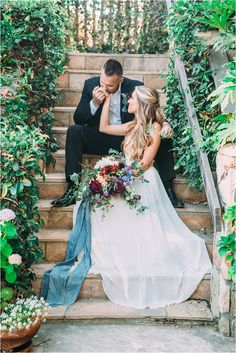 a bride and groom sitting on some steps