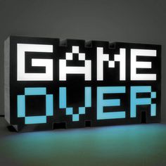 an illuminated sign that says game over in blue and white letters on a black background