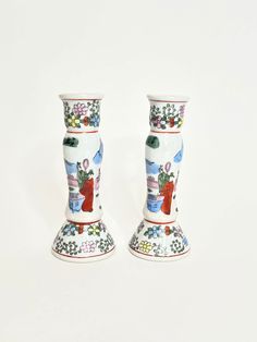 two vases with designs on them sitting side by side against a white background,