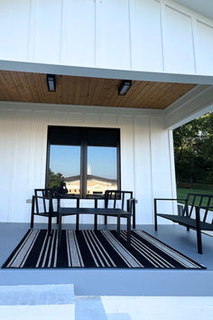 two benches sitting on top of a patio next to a building with windows and doors