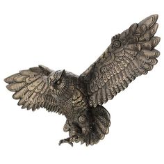 an owl figurine sitting on top of a white surface with its wings spread