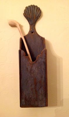 an old rusted metal container with a toothbrush and spoon in it on a wall