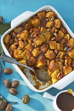 a casserole dish with nuts and caramel sauce in it on a blue table