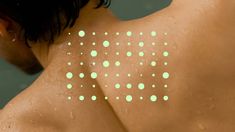 the back of a man with green dots on his chest