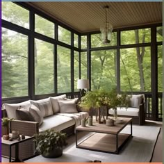 a living room filled with lots of furniture and windows covered in glass walls that look out onto the woods