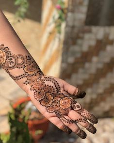 a woman's hand with henna tattoos on it