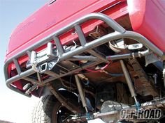 a red truck parked on top of a dirt field