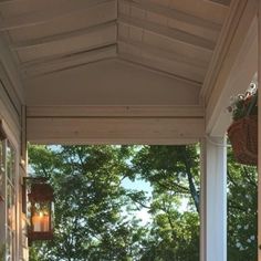 the porch is covered with wicker baskets and plants on it's side wall