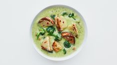 a white bowl filled with broccoli and some kind of meat on top of it