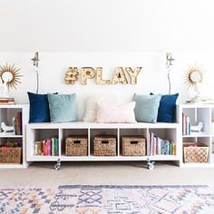 a play room with bookshelves and baskets on the floor in front of it