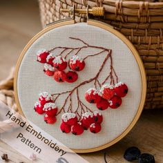 a red and white embroidered cherry blossom on a wooden hoop