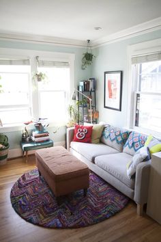 a living room filled with lots of furniture and decor on top of a hard wood floor