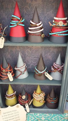 a shelf filled with lots of bracelets and hats on top of eachother