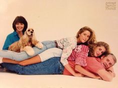 the family is posing for a photo with their dog