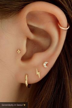 a woman wearing three different ear piercings on her left and right side of the ear