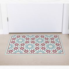 a blue and red rug on the floor in front of a white door with an open door