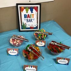 a table topped with bowls filled with different types of gummy bears and desserts