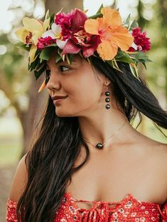 a woman with flowers in her hair wearing a red dress and flower crown on her head