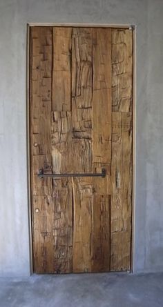 a wooden door sitting on the side of a white wall next to a light fixture