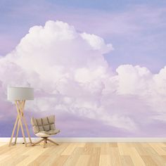 an empty room with a chair, lamp and clouds painted on the wall