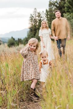 the family is walking through tall grass together