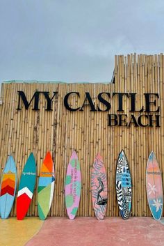 many surfboards are lined up in front of a sign that says my castle beach