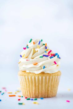 a cupcake with white frosting and sprinkles